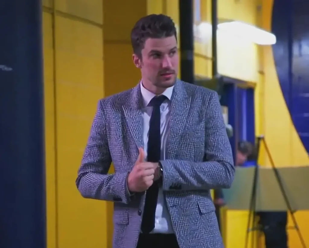 Presumably a hockey player, dressed in a stylish, patterned suit with a white shirt and tie.